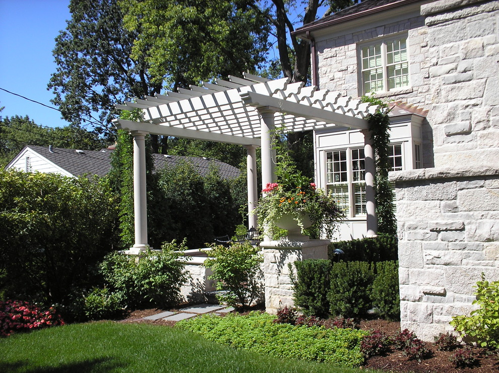 Idee per un grande patio o portico chic dietro casa con pavimentazioni in pietra naturale e una pergola
