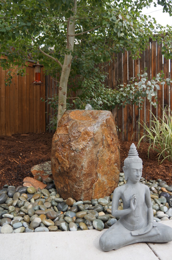 Inspiration for a small courtyard concrete patio fountain remodel in Denver with no cover