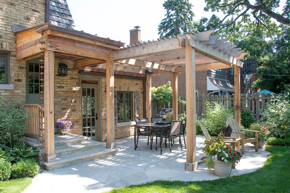 Photo of a classic patio in Chicago with natural stone paving and a pergola.