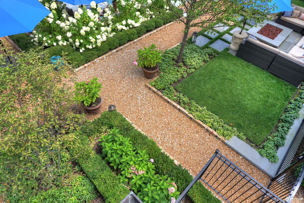 Modelo de jardín clásico de tamaño medio en patio trasero con brasero y gravilla