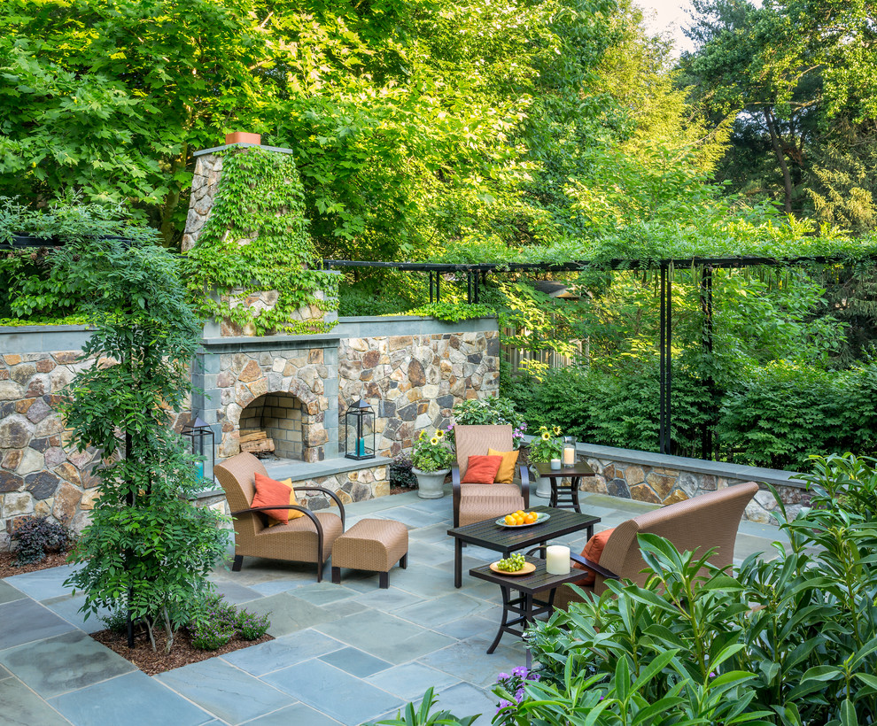 Imagen de patio clásico sin cubierta en patio trasero con adoquines de piedra natural y chimenea