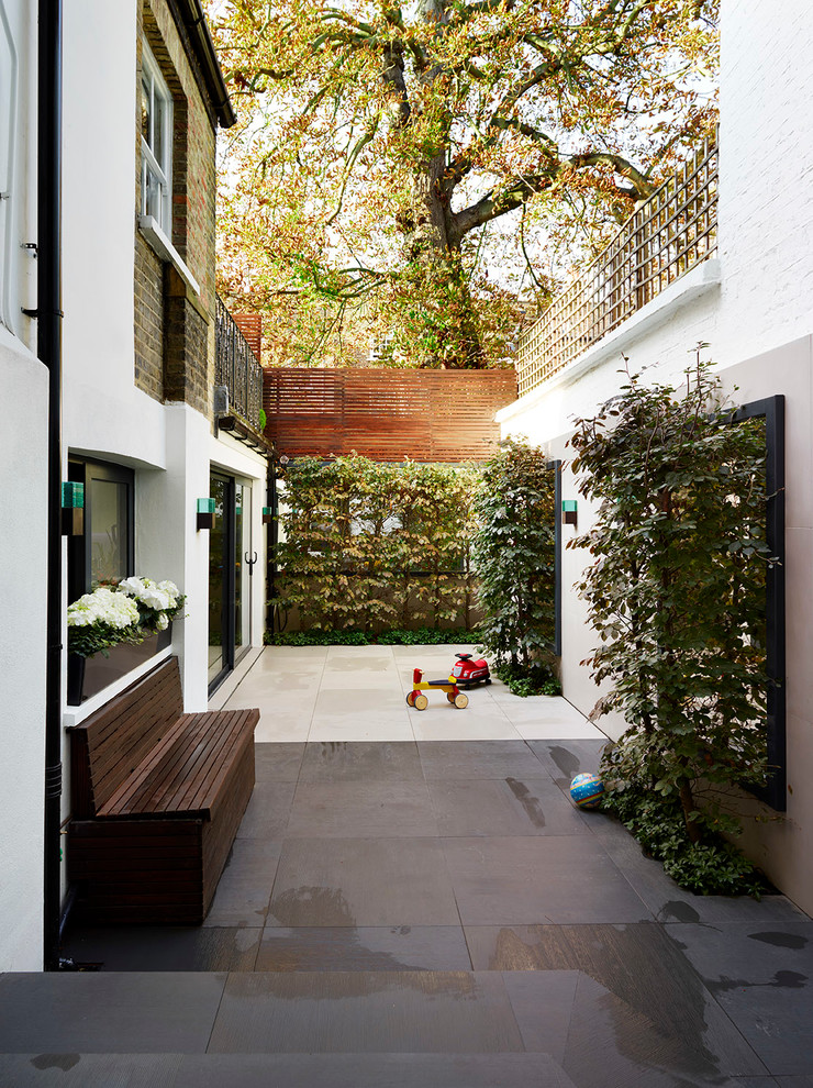 ロンドンにある高級な広いトランジショナルスタイルのおしゃれな横庭のテラス (天然石敷き、日よけなし) の写真