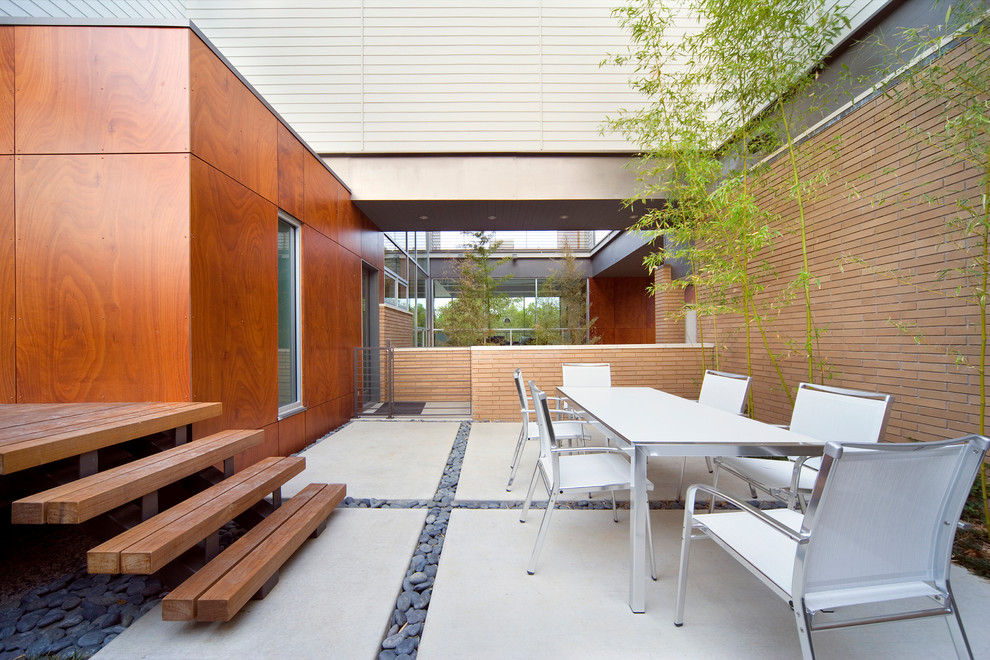 Idée de décoration pour une terrasse design avec des pavés en béton et aucune couverture.