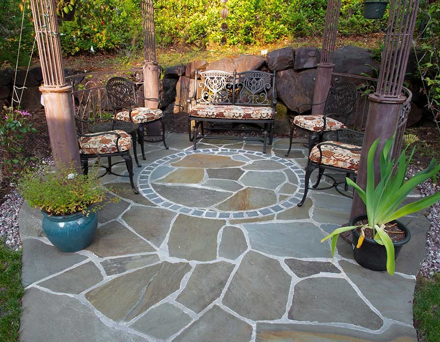 Modelo de patio tradicional grande sin cubierta en patio trasero con adoquines de piedra natural