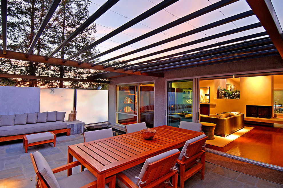 Ispirazione per un patio o portico minimalista di medie dimensioni e davanti casa con pavimentazioni in cemento e un parasole