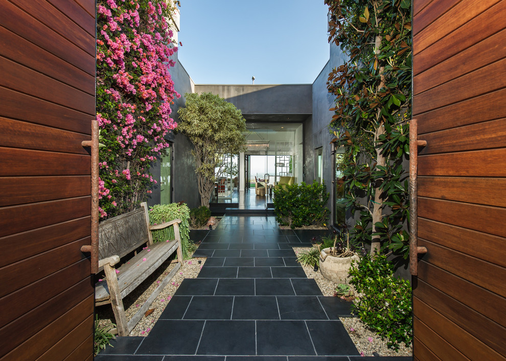 Идея дизайна: большой двор на переднем дворе в стиле фьюжн с покрытием из каменной брусчатки без защиты от солнца