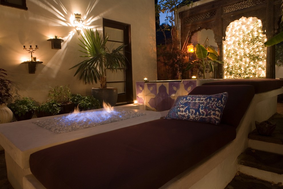 This is an example of a small mediterranean back patio in Los Angeles with a fire feature and natural stone paving.