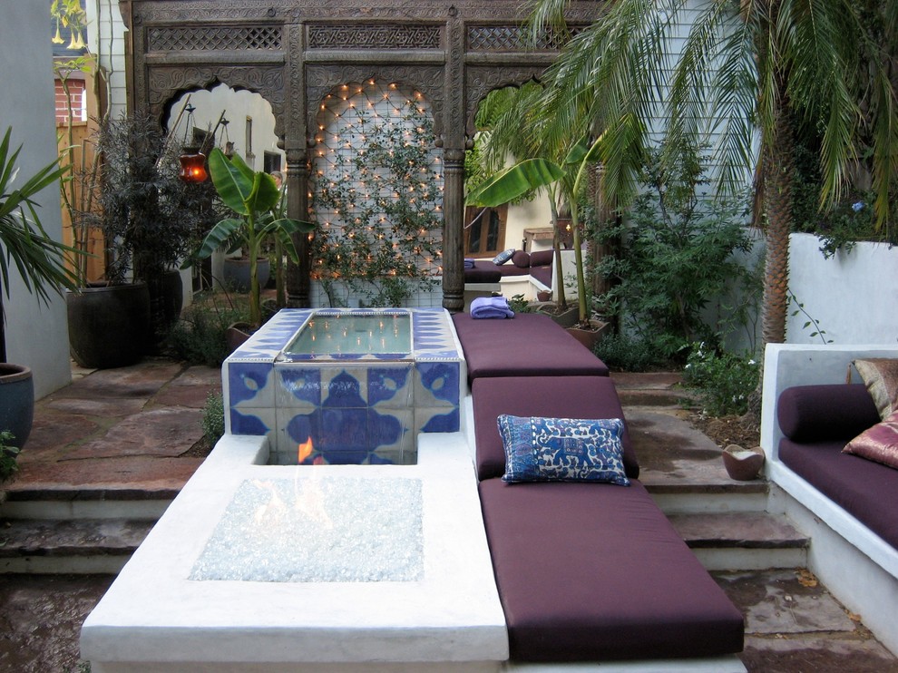 This is an example of a small mediterranean back patio in Los Angeles with a water feature and natural stone paving.
