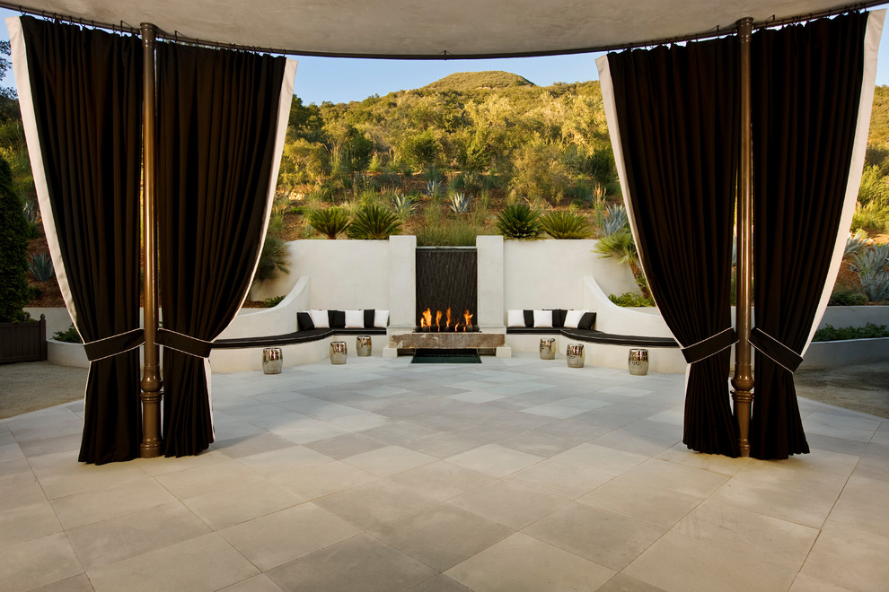 Idée de décoration pour une terrasse tradition avec un foyer extérieur.