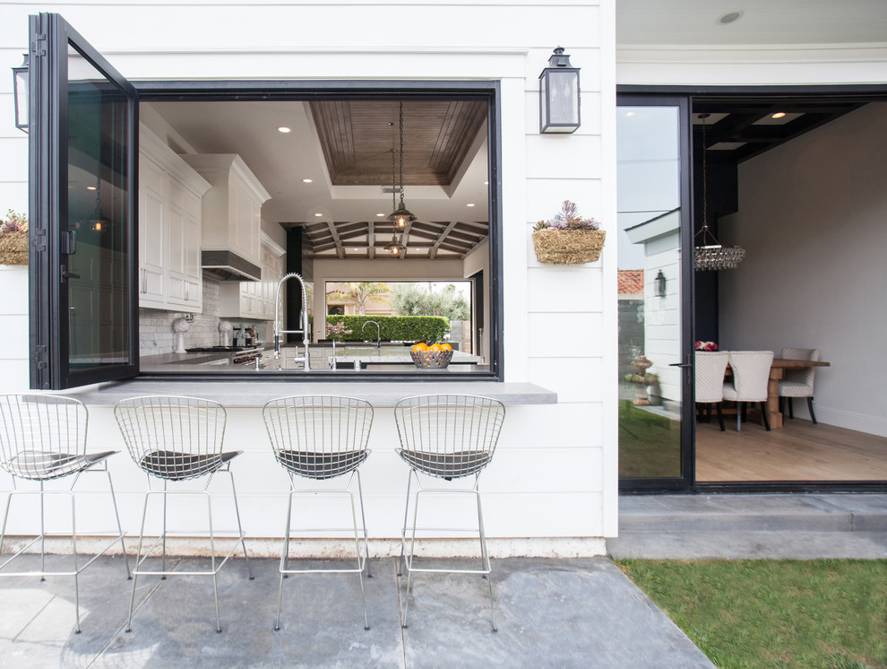 Idee per un patio o portico tradizionale dietro casa con lastre di cemento