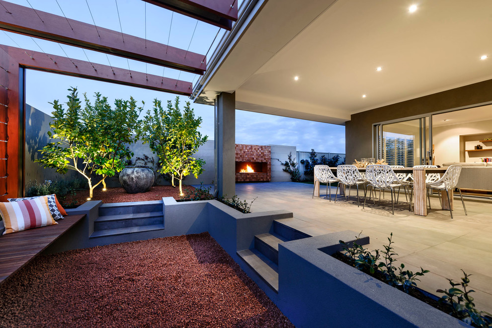 Inspiration pour une grande terrasse arrière design avec des pavés en béton et une extension de toiture.