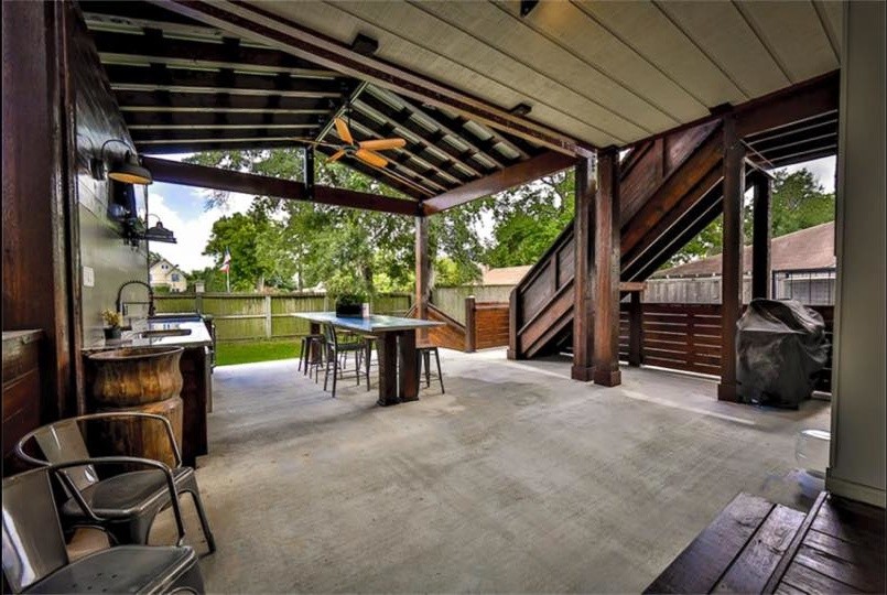 Idée de décoration pour une grande terrasse arrière urbaine avec une cuisine d'été, une dalle de béton et une extension de toiture.