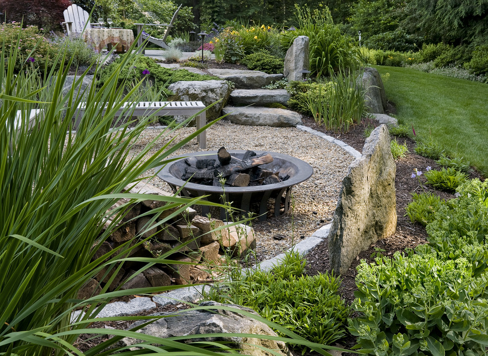 Ejemplo de jardín tradicional en patio trasero con brasero y adoquines de piedra natural