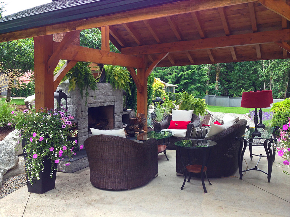 Medium sized world-inspired back patio in Vancouver with concrete slabs, a pergola and a fire feature.