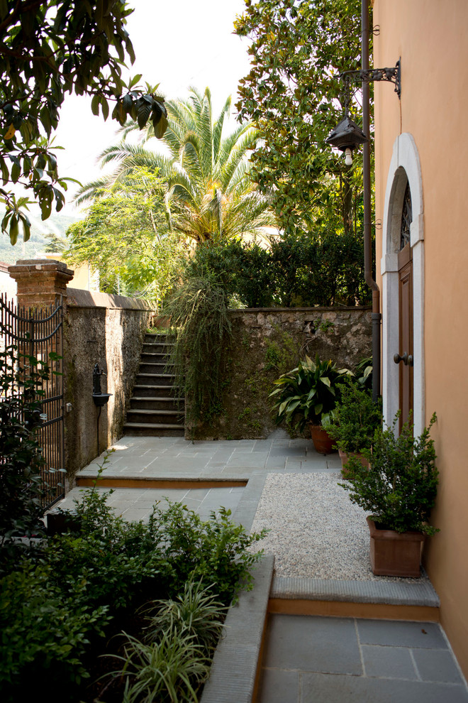 Idee per un piccolo patio o portico classico davanti casa con pavimentazioni in pietra naturale e nessuna copertura