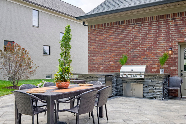 Aménagement d'une terrasse arrière classique de taille moyenne avec une cuisine d'été, des pavés en béton et aucune couverture.