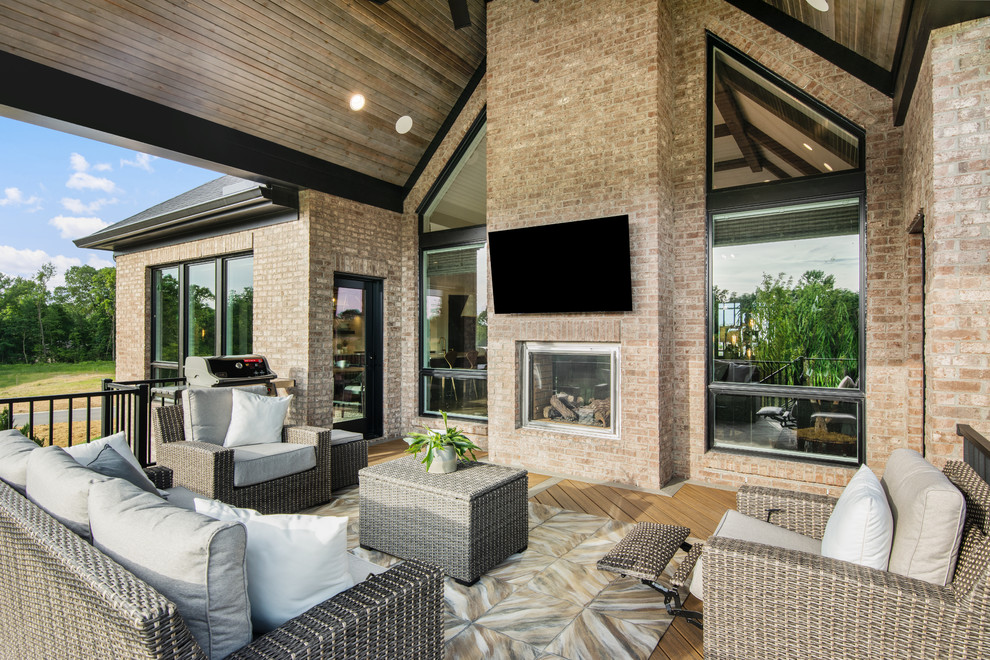 Expansive classic back patio in Cincinnati with a fireplace and a roof extension.