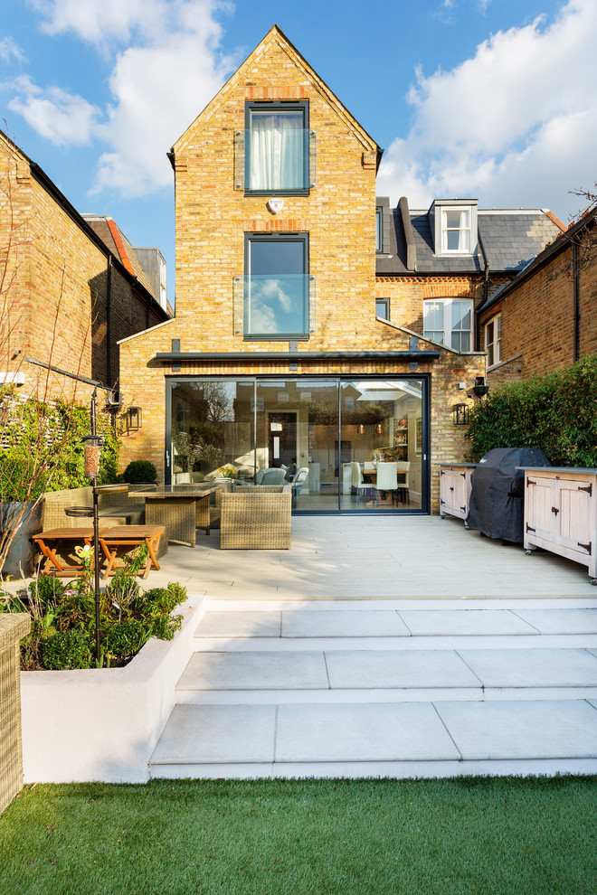 Inspiration for a medium sized contemporary back patio in London with concrete paving.