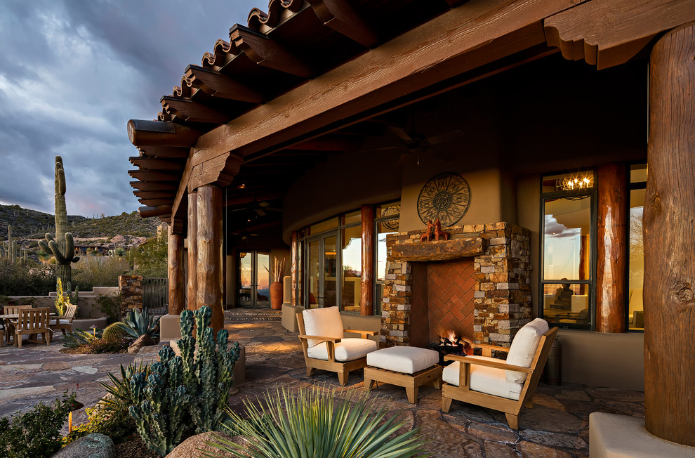フェニックスにあるサンタフェスタイルのおしゃれな裏庭のテラス (張り出し屋根、屋外暖炉) の写真