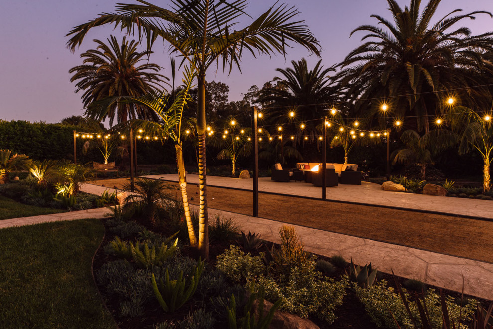 Идея дизайна: большой двор на заднем дворе в средиземноморском стиле с уличным камином и покрытием из декоративного бетона без защиты от солнца