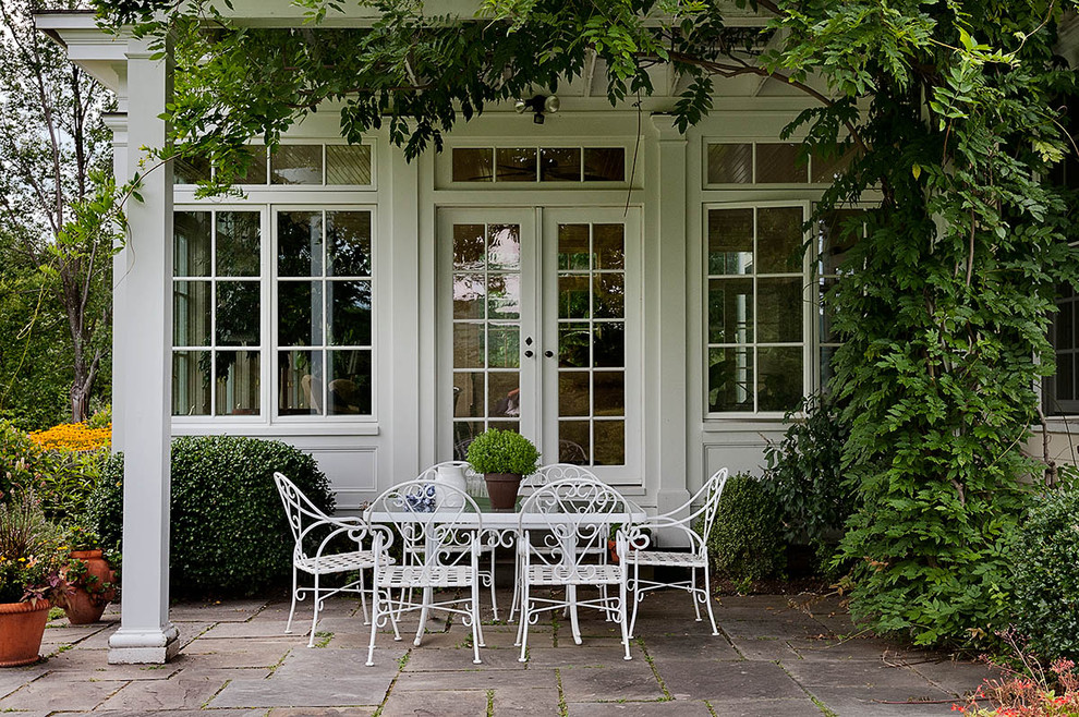 French country patio photo in New York with a pergola