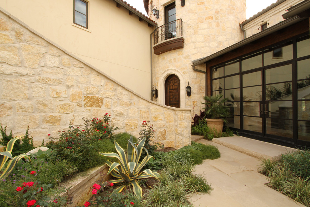 Design ideas for a large mediterranean courtyard patio in Austin with a fire feature, natural stone paving and no cover.