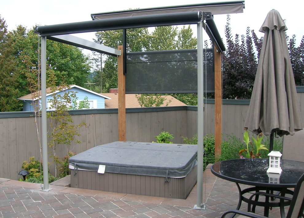 Diseño de patio clásico de tamaño medio en patio trasero con adoquines de ladrillo y toldo