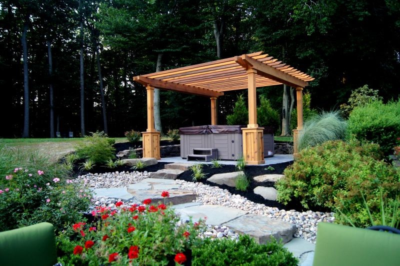 Hot Tub Placed in Natural Setting with Stone Steps and Pergola Traditional Patio