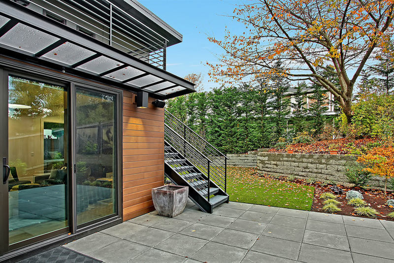 This is an example of a medium sized modern back patio in Seattle with concrete paving and an awning.