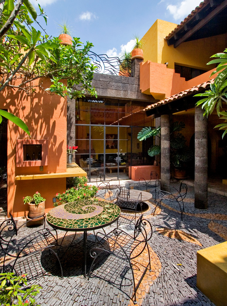 Esempio di un patio o portico boho chic in cortile e di medie dimensioni con un giardino in vaso e pavimentazioni in pietra naturale