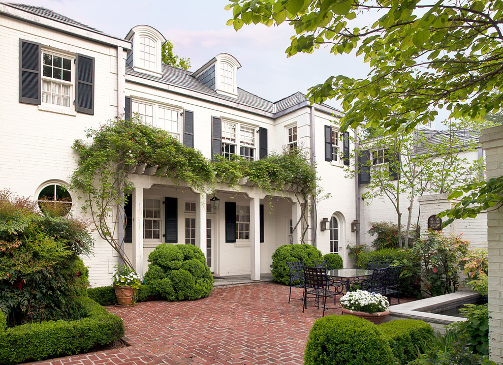 Inspiration for a mid-sized timeless courtyard brick patio fountain remodel in Nashville with a pergola