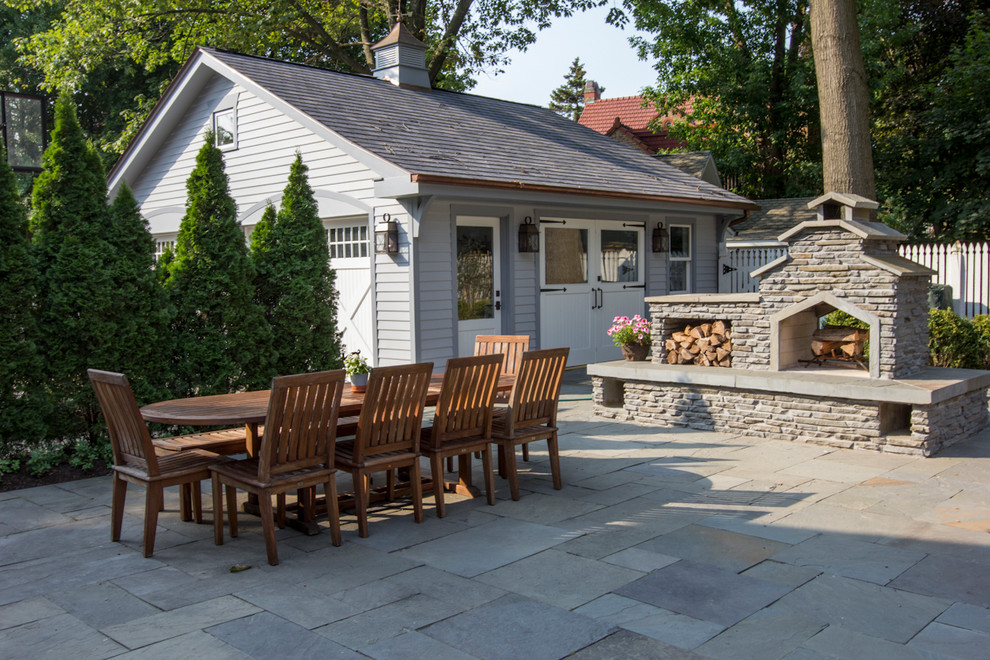 Esempio di un grande patio o portico country dietro casa con un focolare e pavimentazioni in pietra naturale