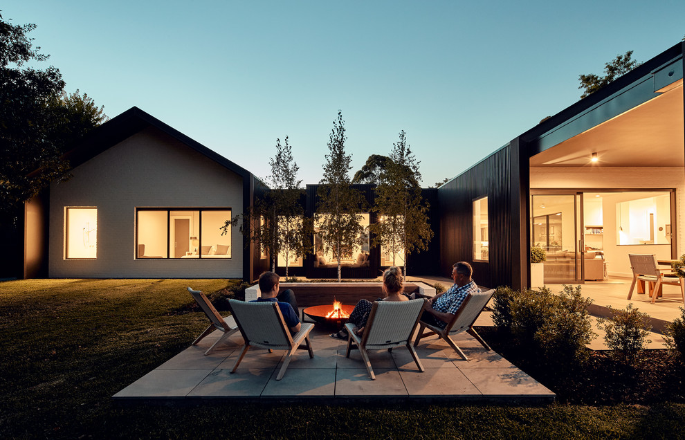 Große Moderne Pergola hinter dem Haus mit Feuerstelle und Natursteinplatten in Melbourne