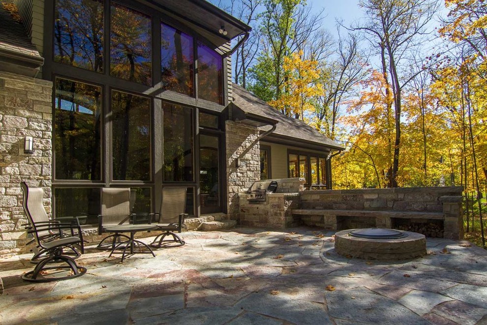 Example of a large classic backyard stone patio kitchen design in Atlanta with no cover