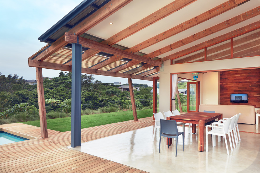 Contemporary patio in Other with a roof extension.