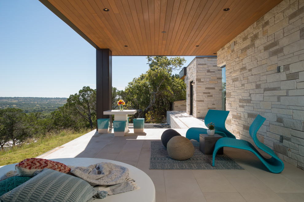 Idée de décoration pour une terrasse arrière design de taille moyenne avec des pavés en béton et une extension de toiture.
