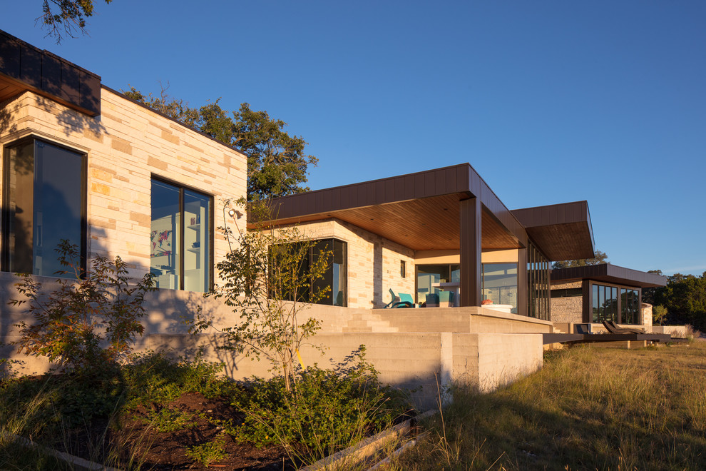 This is an example of a large contemporary back patio in Austin with concrete paving and a roof extension.