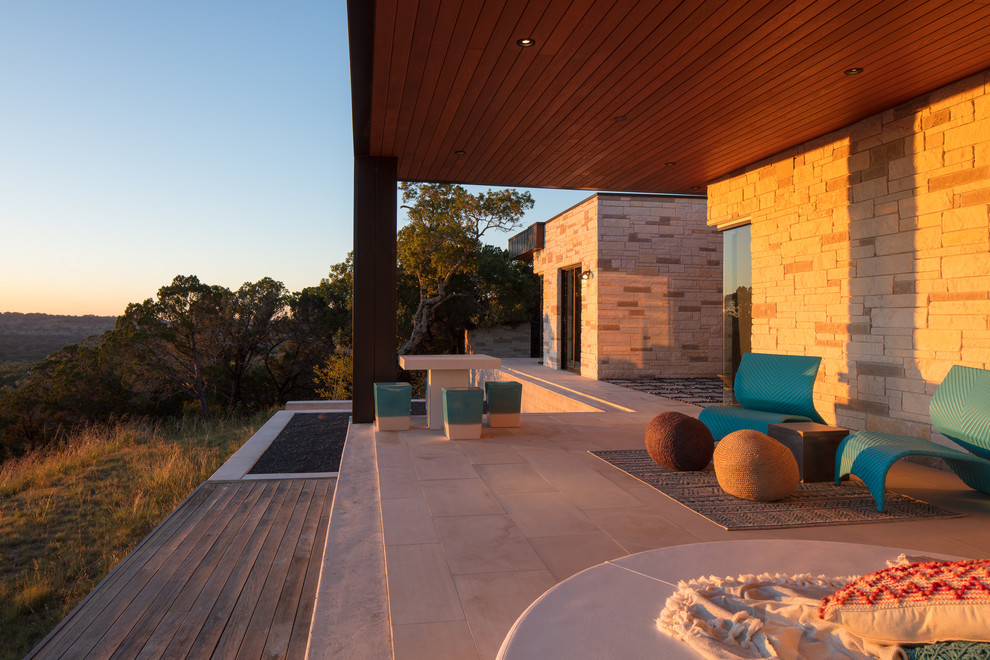 Photo of a large contemporary back patio in Austin with concrete paving and a roof extension.