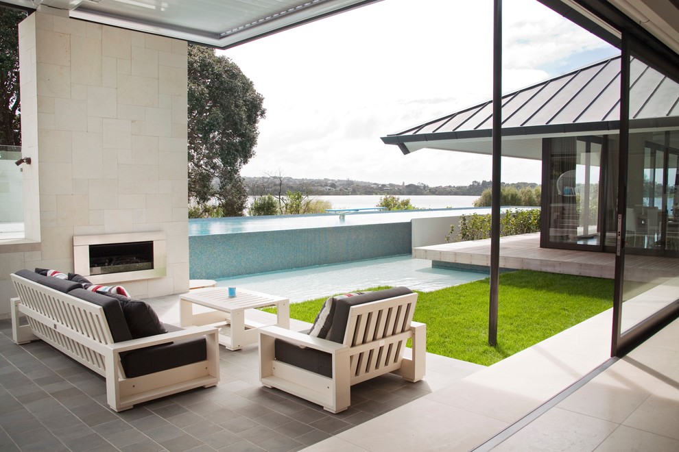 Contemporary patio in Auckland with a fire feature and decking.