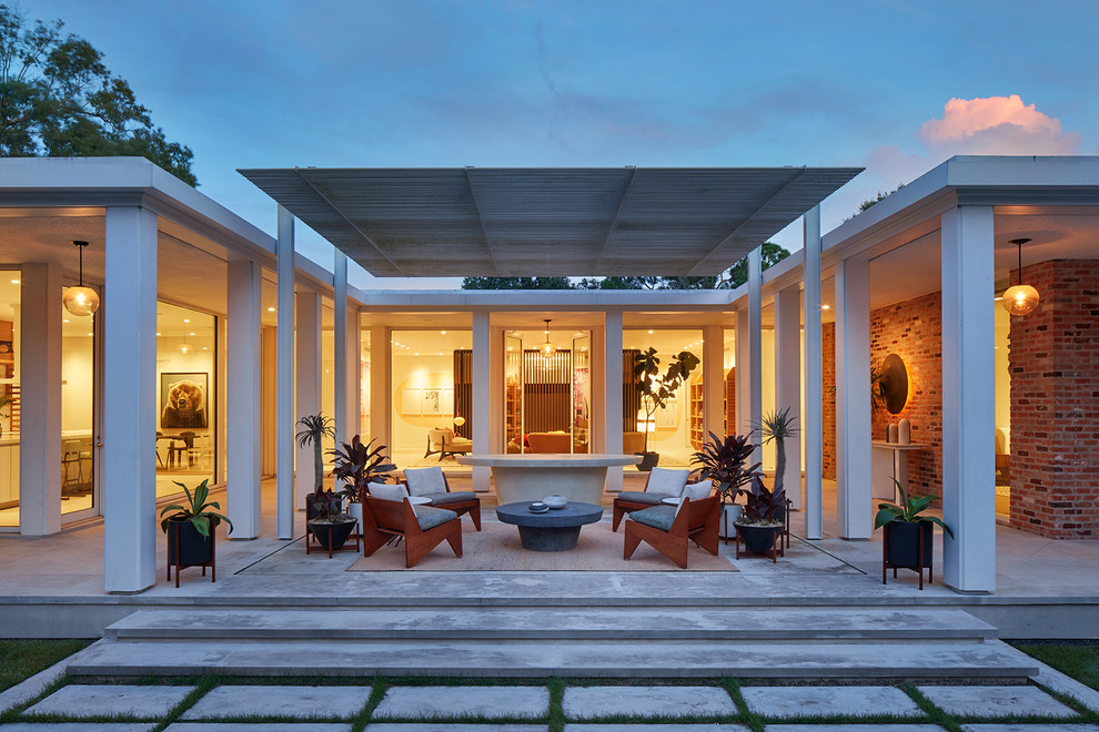 Mid-century modern backyard patio photo in Houston with a pergola