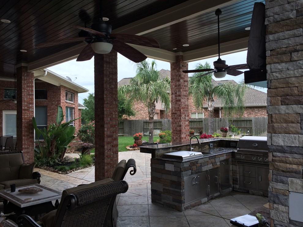 Esempio di un grande patio o portico design dietro casa con cemento stampato e un tetto a sbalzo