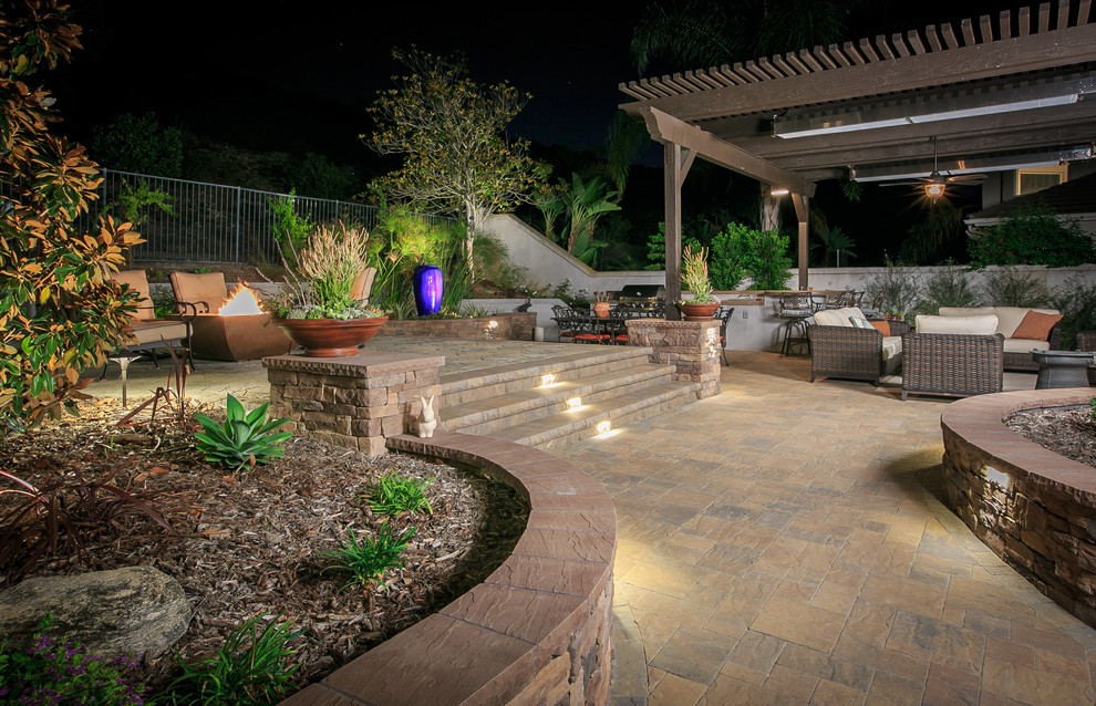 Large elegant backyard concrete paver patio photo in San Diego with a fire pit and a pergola
