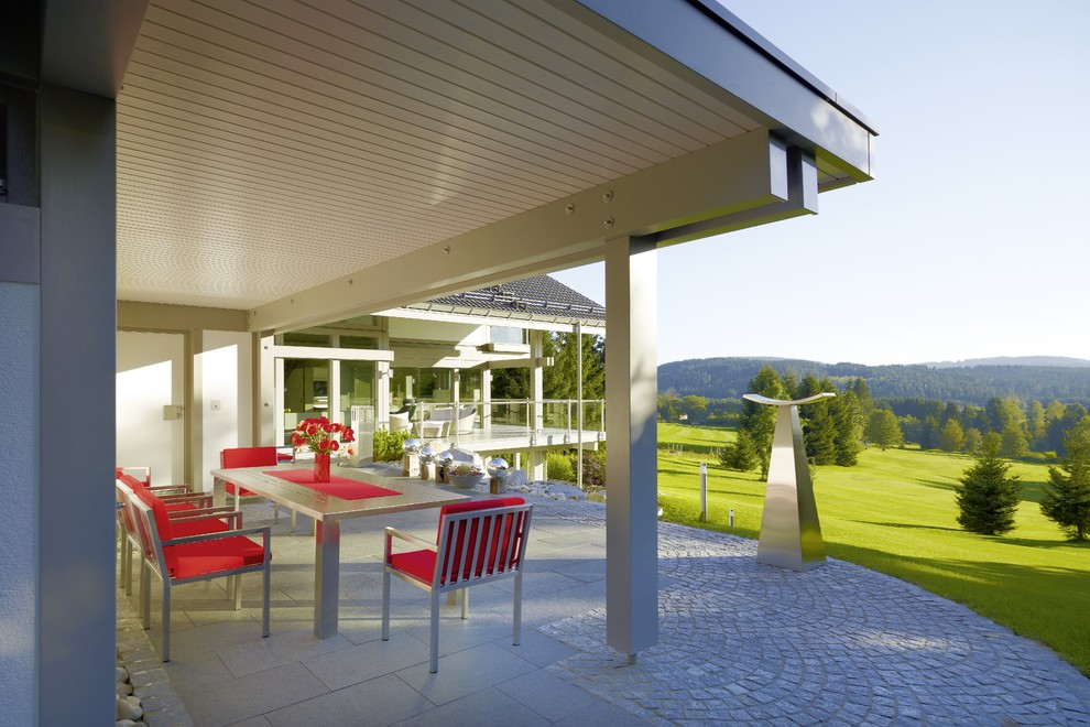 Immagine di un grande patio o portico minimalista nel cortile laterale con pavimentazioni in pietra naturale