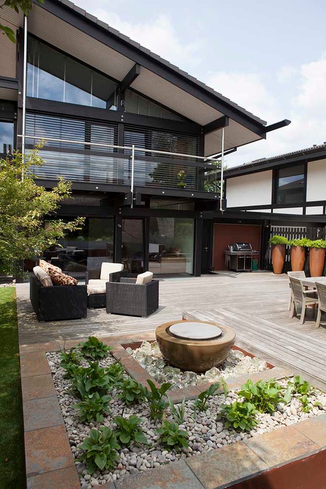 This is an example of a contemporary back patio in London with no cover.