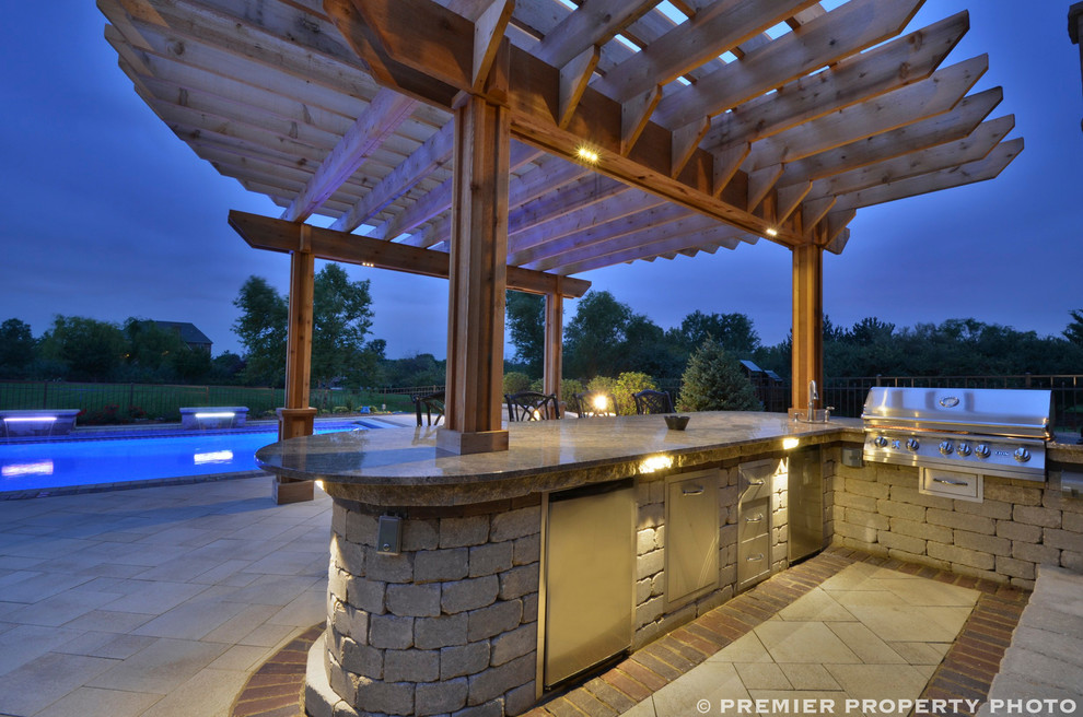 Inspiration for a huge contemporary backyard concrete paver patio kitchen remodel in Chicago with a pergola
