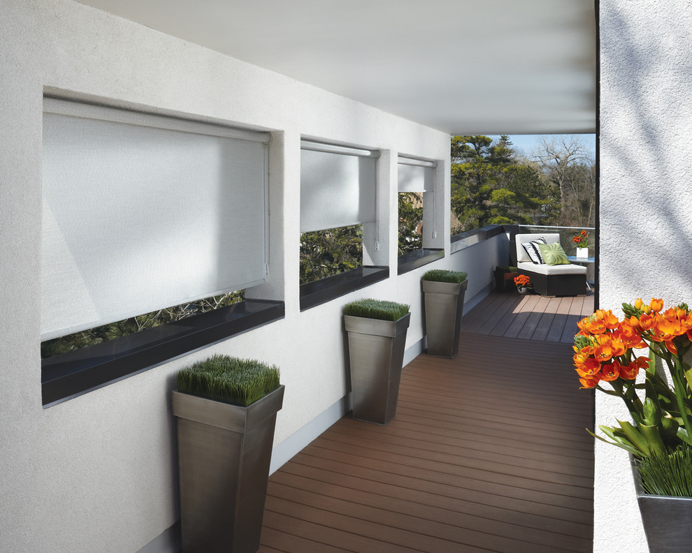 Esempio di un ampio patio o portico minimalista dietro casa con pedane e un tetto a sbalzo
