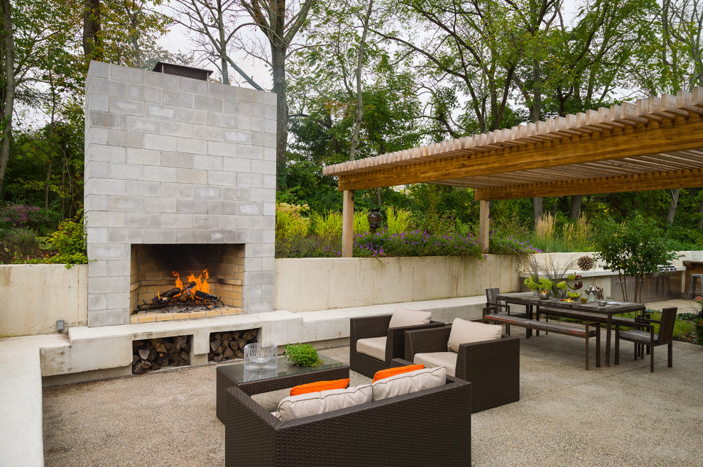 Diseño de patio contemporáneo en patio trasero con pérgola y chimenea