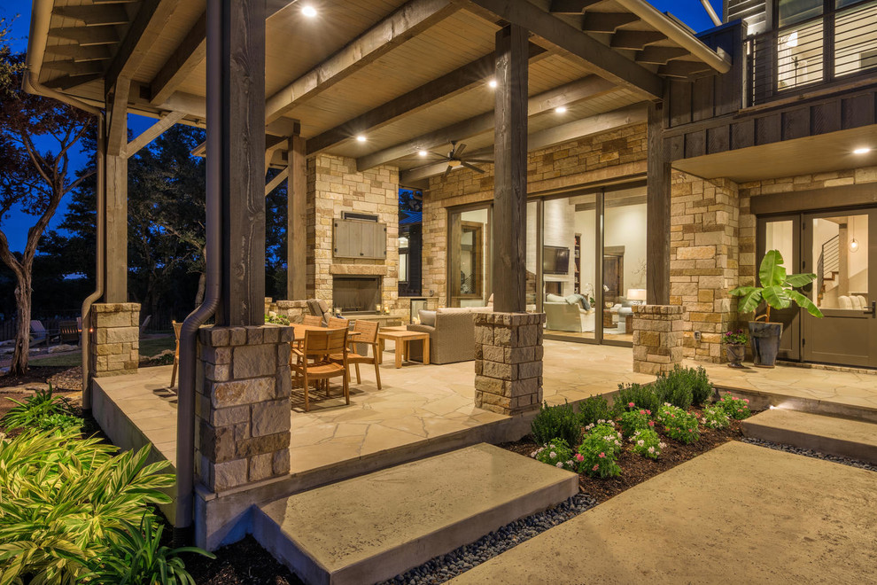 Large transitional backyard concrete patio photo in Austin with a fireplace and an awning