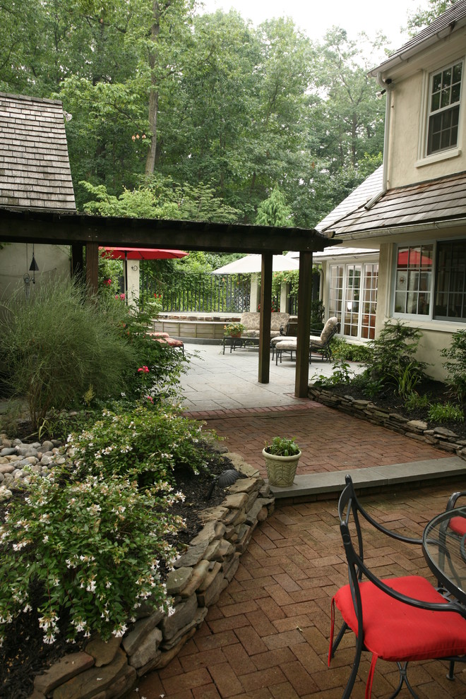 Foto di un patio o portico chic di medie dimensioni e nel cortile laterale con pavimentazioni in mattoni e nessuna copertura