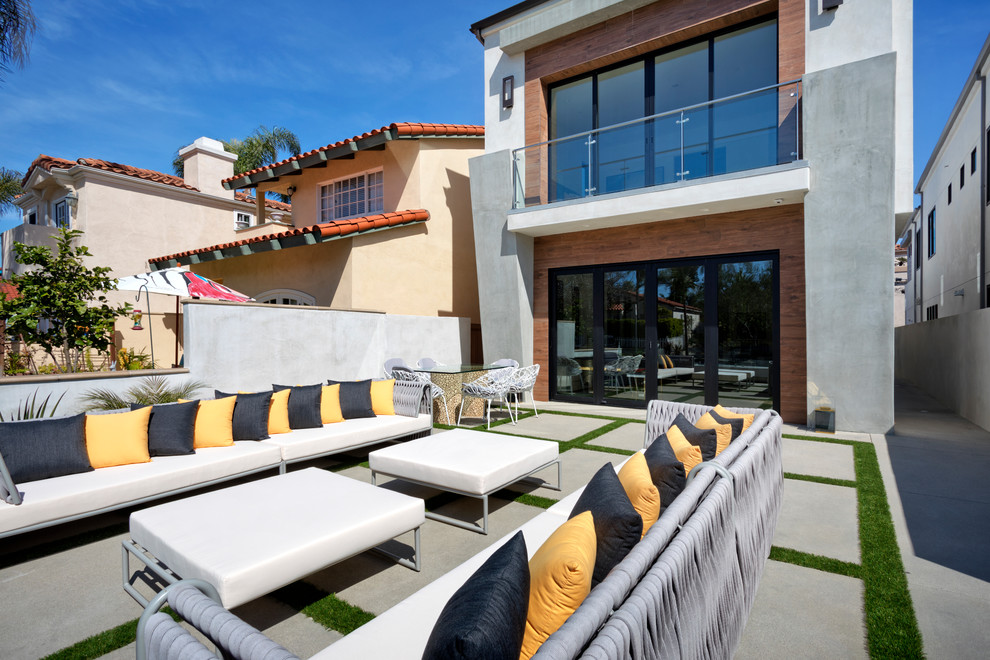 Cette photo montre une terrasse arrière tendance de taille moyenne avec des pavés en béton et aucune couverture.